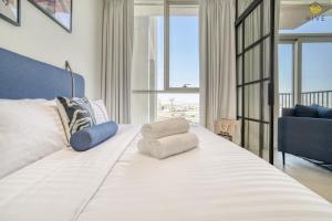 迪拜Lovely 1 Bedroom Apartment in Collective 2.0的卧室配有一张白色大床和椅子