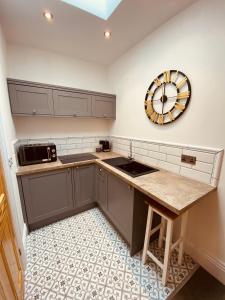 韦茅斯Self Contained Guest suite 2 - Weymouth的厨房配有水槽和墙上的时钟