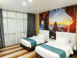 BaybayFan's Hotel的两张位于酒店客房的床,墙上挂着一幅画