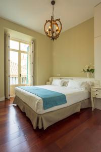 马拉加Madeinterranea Apartments的配有吊灯的卧室内的一张大床