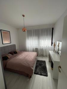 比哈奇Paradise的一间卧室配有一张床、一张桌子和一个窗户。