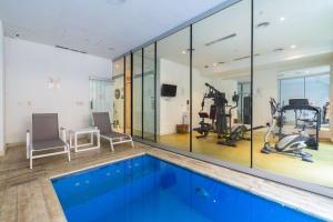 布宜诺斯艾利斯Boutique Suites Palermo的健身房设有游泳池和健身器材