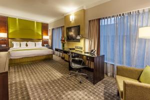 新加坡Holiday Inn Singapore Orchard City Centre, an IHG Hotel的配有一张床和一张书桌的酒店客房