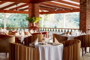 维多利亚瀑布Pioneers的餐厅设有白色的桌椅和窗户。