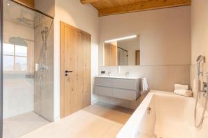 韦斯滕多夫Chalet 149 Westendorf by ALPS RESORTS的带浴缸、水槽和淋浴的浴室