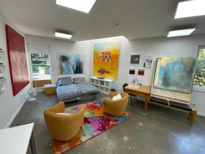 鲁尔河畔米尔海姆Atelier-Ferienwohnung的客厅配有一张床、椅子和绘画作品