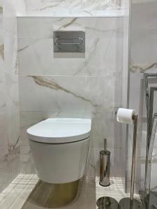 塞维利亚SUITES SAN ESTEBAN 16 Real的浴室内的白色马桶,配有卫生纸饮水机