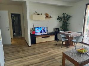韦莱斯Villa Lucija的客厅配有桌子和电视。