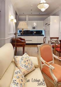 塞维利亚SUITES SAN ESTEBAN 16 Real的带沙发和椅子的客厅以及厨房。