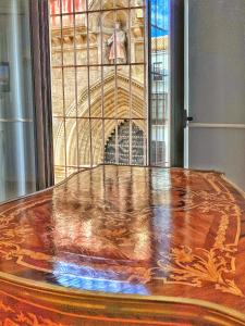 塞维利亚SUITES SAN ESTEBAN 16 Real的彩色玻璃窗前的木桌