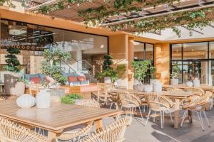 莫罗德哈布雷Iberostar Playa Gaviotas All Inclusive的餐厅设有木桌、椅子和窗户。
