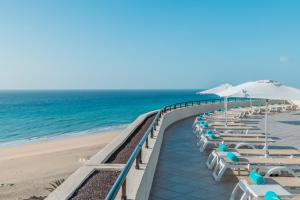 莫罗德哈布雷Iberostar Playa Gaviotas All Inclusive的海滩上的一排椅子和遮阳伞