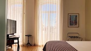 里斯本莎杜卡萨杜拜鲁旅馆的一间卧室设有一张床、一台电视和一个窗口。