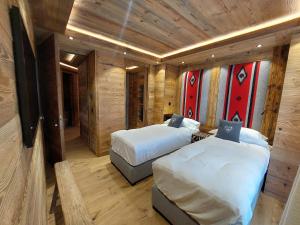 夏蒙尼-勃朗峰卡尔兹蒙布兰科酒店的木墙客房的两张床