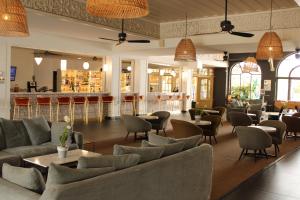 圣丹尼斯Hôtel Exsel Créolia的一间带沙发和桌子的餐厅和一间酒吧
