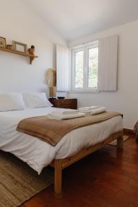 Maria VinagreCasa da Maria • Natural Côte • Aljezur的一间卧室配有一张带白色床单的床和一扇窗户。