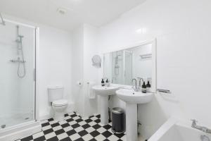 布莱顿霍夫Beachside Retreat 2-Bedroom Gem with FREE Private Parking & Outdoor Space的浴室配有2个盥洗盆、卫生间和淋浴。