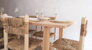 纳瓦哈斯Casa El Olmo de Navajas的一张木桌,配有椅子和盘子,酒杯