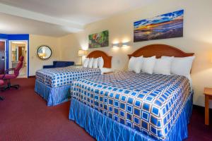 新帕尔茨Rodeway Inn & Suites New Paltz- Hudson Valley的酒店客房配有两张床和一张书桌