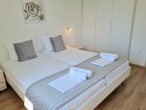 克尔克Apartman Maslina的卧室设有两张床,拥有白色的墙壁和木地板