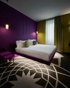 罗马MyTALE Creative Academy Hotel的一间卧室设有一张紫色墙壁的大床