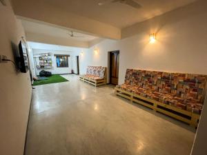 蓬蒂切里Eness Hostels Pondicherry的一间客厅,客厅配有沙发和椅子