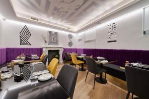 罗马MyTALE Creative Academy Hotel的餐厅设有桌椅和紫色墙壁