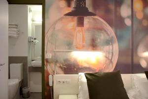 巴黎贝斯特韦斯特巴纳斯峰酒店的浴室内一张挂在床上的大玻璃灯