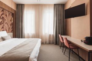 波佩林赫阿姆弗拉酒店的酒店客房配有一张床、一张书桌和一台电视。