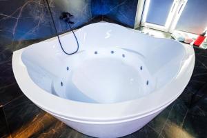 克拉斯诺达尔HouseX的带窗户的浴室内的白色浴缸