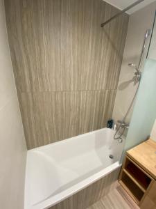 巴拉通雷勒Premium Lelle Waterfront Resort Bonnie的浴室设有白色浴缸,拥有木墙