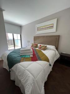 科尔多瓦Comfort Center Inn的一间卧室配有一张大床和色彩缤纷的毯子