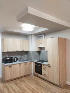 华沙Fajny apartament z parkingiem, obok metra.的空厨房,配有木制橱柜和水槽