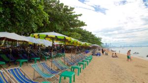 南芭堤雅Max's Beach House的海滩上的一组椅子和遮阳伞