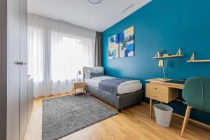 莱茵费尔登Ambrosia Guesthouse的一间卧室配有一张床、一张桌子和一面蓝色的墙壁
