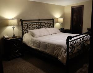 Centerport恰勒特宾馆及套房的卧室内的一张床位,配有两盏灯和两张桌子