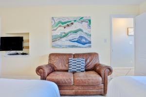 德斯坦Summer Haven D的卧室里一张棕色皮椅,上面有绘画作品
