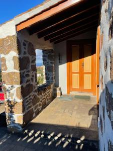 蓬塔利亚纳Casa Gabriela的一座石头建筑的入口,带橙色门