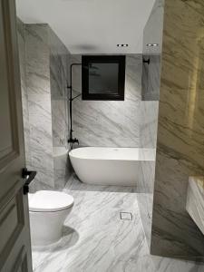 多哈The Key - Luxury Apartment的带浴缸和卫生间的浴室。