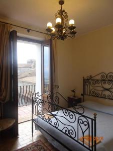 阿尔托蒙泰Castello di Altomonte的一间卧室配有一张带吊灯的床和一个阳台
