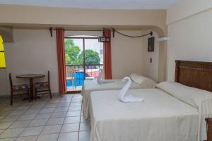 阿卡普尔科Hotel Hacienda María Eugenia的酒店客房带两张床,还有天鹅