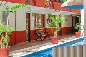 阿卡普尔科Hotel Hacienda María Eugenia的游泳池旁带长凳的房子