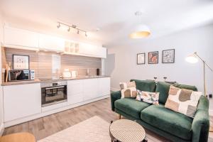 贝里圣埃德蒙兹Guildhall Street Apartment的一间带绿色沙发的客厅和一间厨房