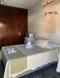 布卢梅瑙Suíte Aconchego的一间卧室配有一张床,上面有两条毛巾