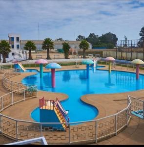 卡塔赫纳Valle de leones的一个带滑梯和遮阳伞的大型游泳池