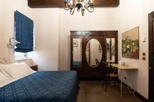 尼科洛西多拉塔别墅酒店的一间卧室配有一张床、一张桌子和一面镜子