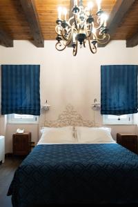 尼科洛西多拉塔别墅酒店的一间卧室配有一张带蓝色窗帘和吊灯的床。