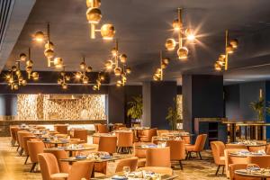 赫尔格达Pickalbatros Blu Spa Resort - Adults Friendly 16 Years Plus- Ultra All-Inclusive的用餐室配有桌椅和吊灯。