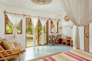 图卢姆Dos Ceibas Tulum Feel Good Hotel的卧室配有一张床和一张桌子及椅子