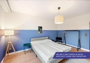 巴塞尔Becozy Self Check-in Hotel Basel an der Messe的一间卧室设有一张床和蓝色的墙壁
